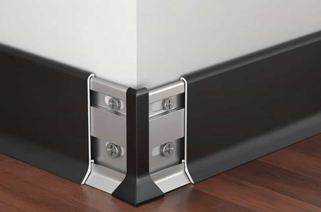 Close-up of a robust aluminium skirting board providing wall protection at a standard internal corner junction in a high-traffic area.